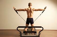 man on reformer with back to us